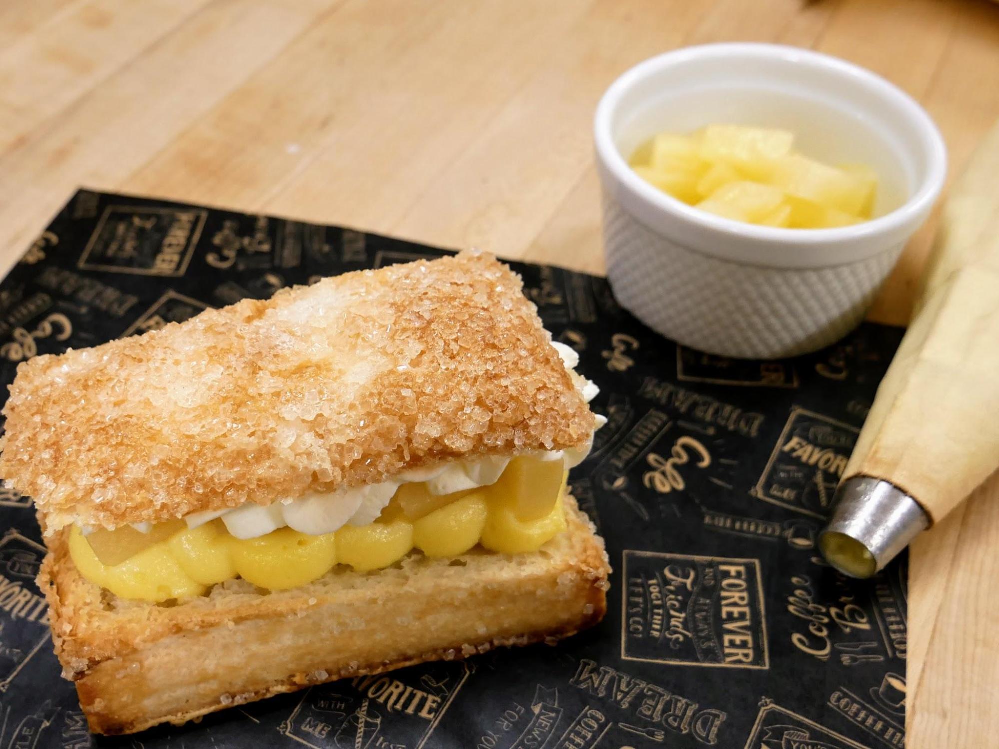 A unique pastry, called the pineapple crunch, made at The Rolling Pin Bakery in Hope, BC. Layers of bavarian custard, whipped cream, and pineapple sandwiched in puff pastry. 